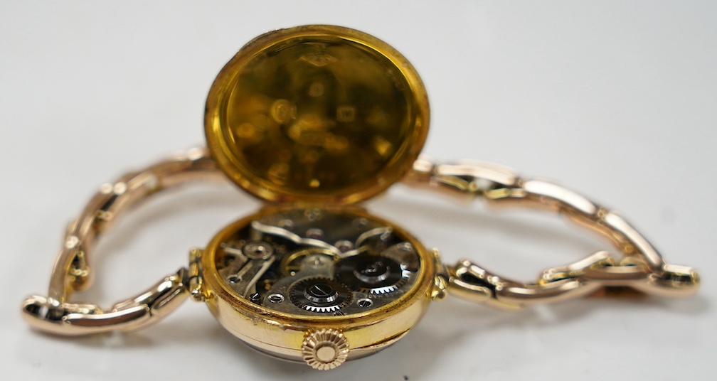 A lady's early 20th century 9ct gold manual wind wrist watch, with Arabic dial, on a 9ct expanding bracelet, gross weight 21.7 grams. Condition - fair to good